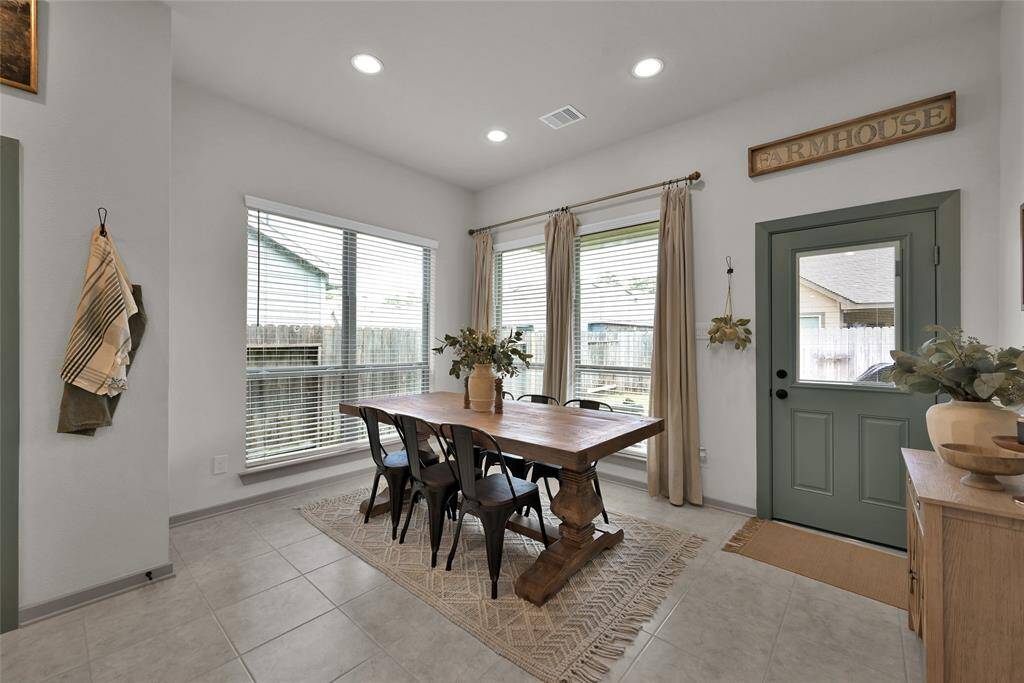 The lovely dining area features large windows and an attractive back door that opens to the backyard, creating a bright and inviting space for meals and gatherings.