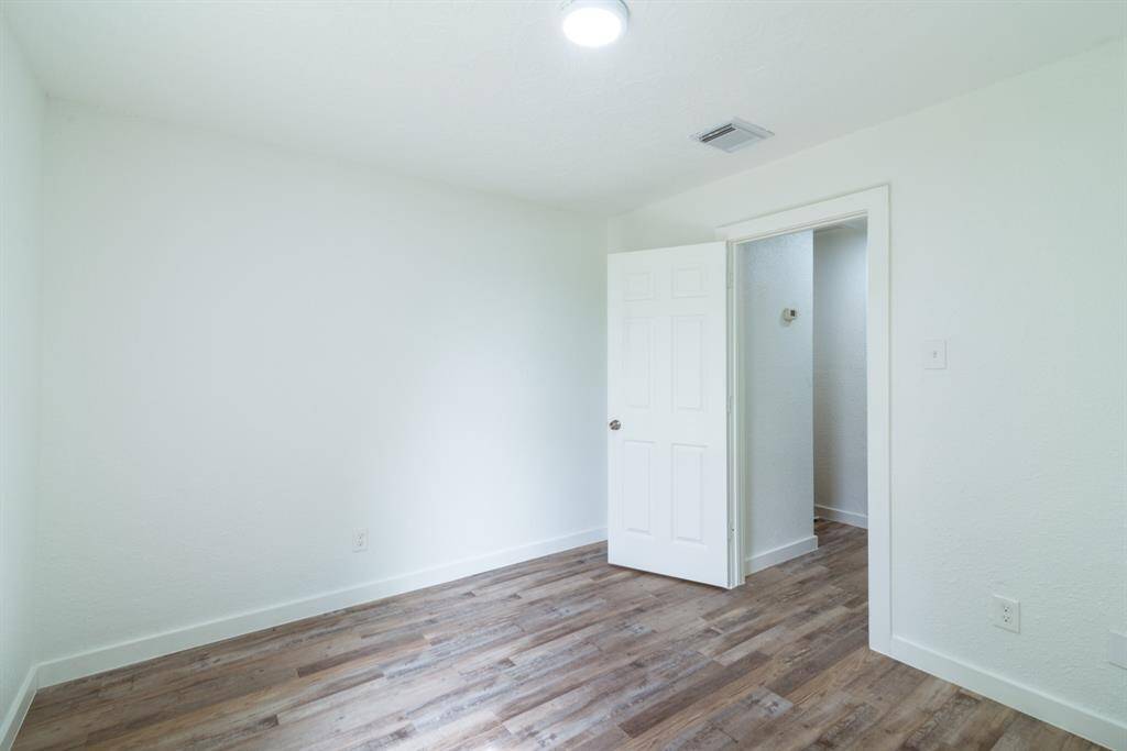 This photo shows a modern bathroom vanity area with a sleek sink, a stylish wooden-framed mirror, and bright lighting, offering a clean and contemporary feel.