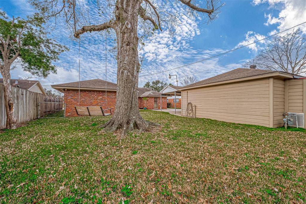 This charming backyard offers a spacious and inviting outdoor setting .A beautiful mature tree serves as the centerpiece, providing ample shade and a serene natural atmosphere