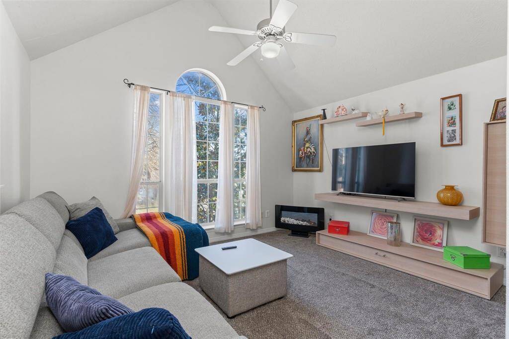 The game room features high vaulted ceilings and a ceiling fan for added comfort and style.