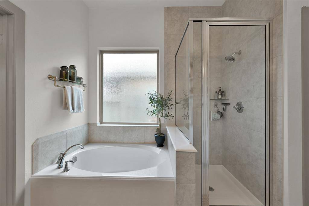 Enjoy the soaking bathtub and separate glass-enclosed shower,complemented by natural lightfrom a frosted window.