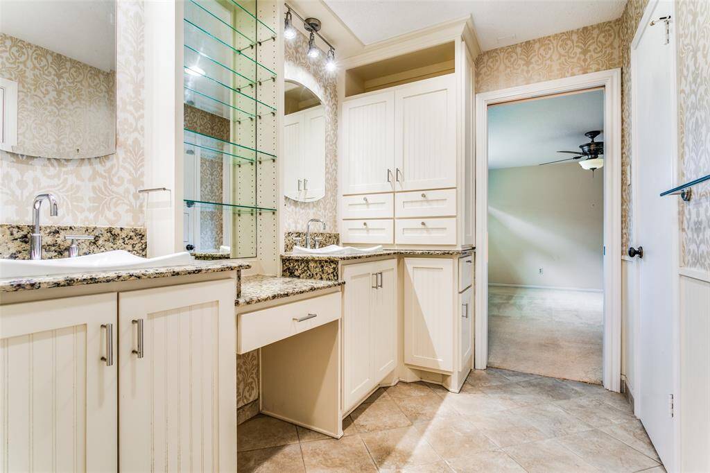 Custom cabinets along with recessed medicine cabinets provide storage in primary.