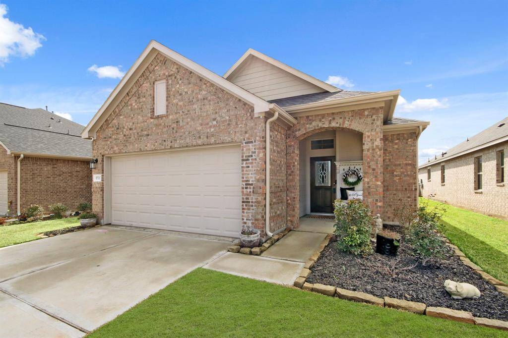 Walk up to a welcoming front porch. Features well-maintained landscaping, a cozy entryway, and a spacious driveway.