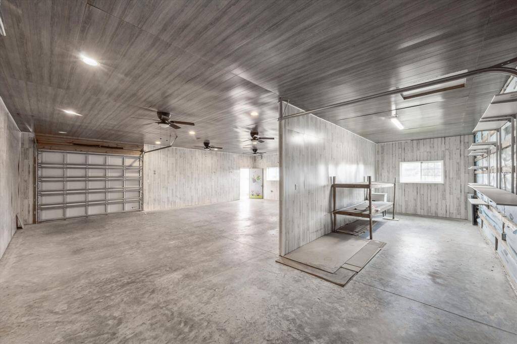 View from the back of the shop, window, shop sink, recessed lights, ceiling fans