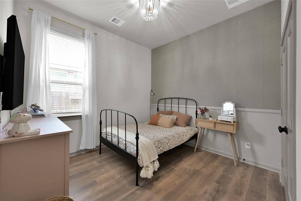 Cozy, well-lit bedroomfeaturing elegant light grey wallswith white trim and modernupgraded flooring.