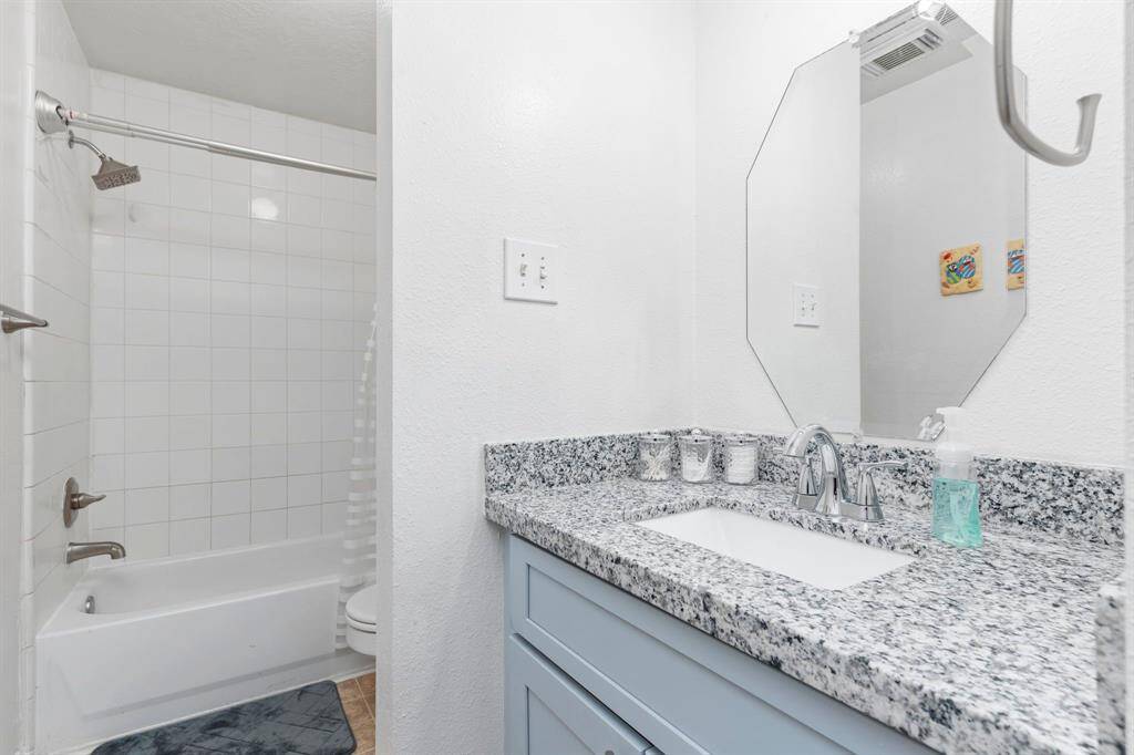 The guest bathroom has been beautifully updated with stunning granite countertops, a deep undermount sink, elegant shaker-style cabinets, and more!