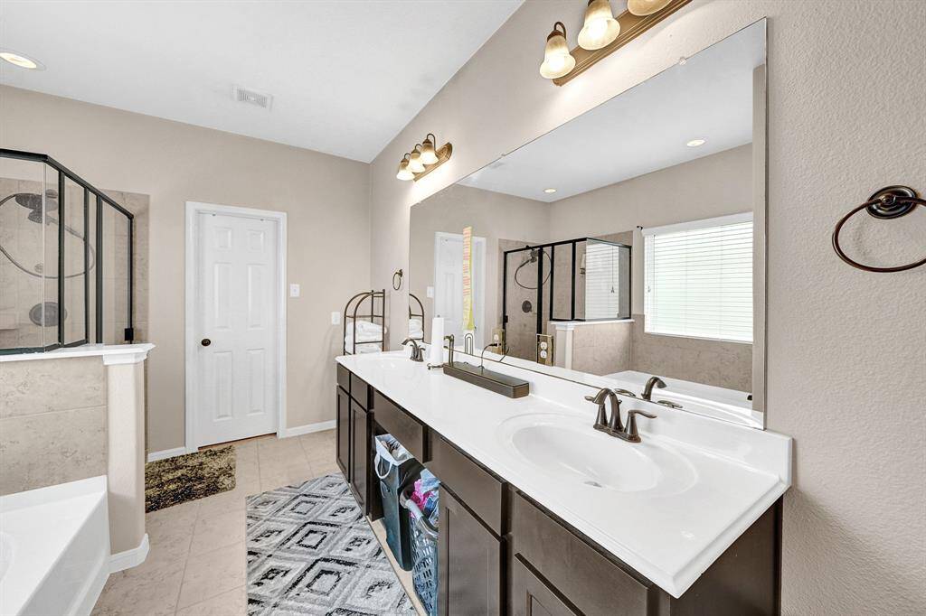Primary en-suite bath with separate shower/tub combo and double sinks