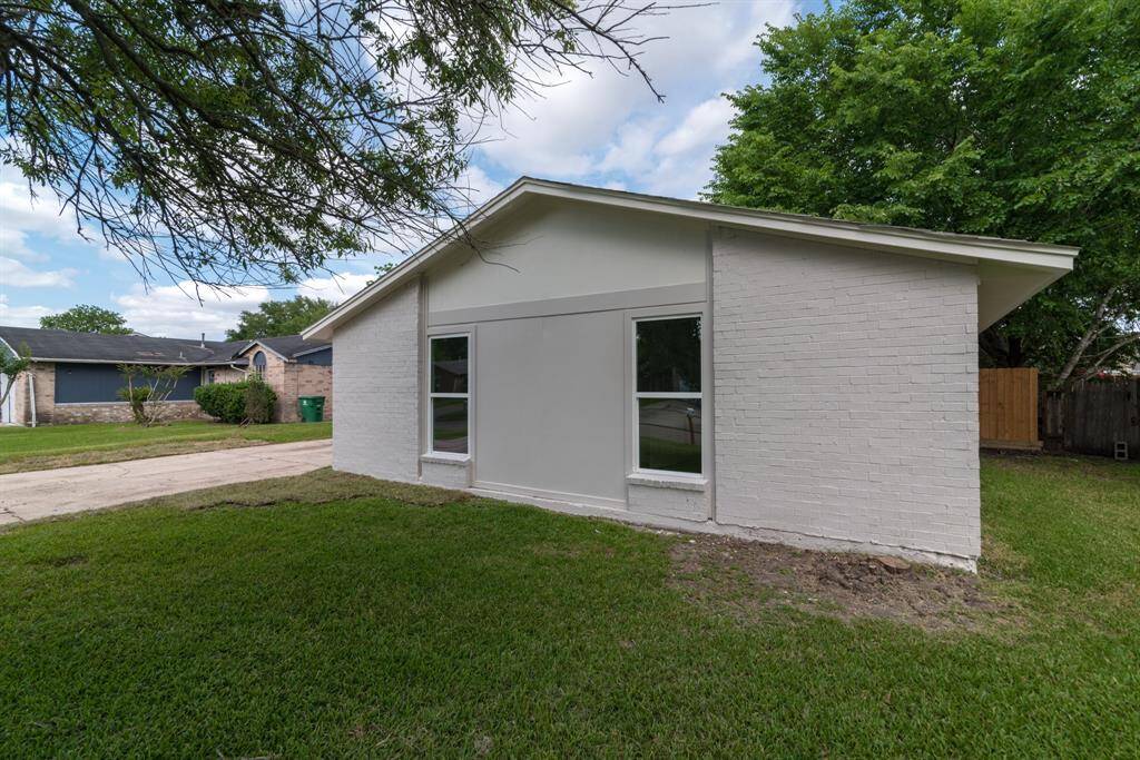 Spacious backyard with a well-maintained lawn, privacy fence, and a large tree providing shade. Ideal for outdoor activities and relaxation.