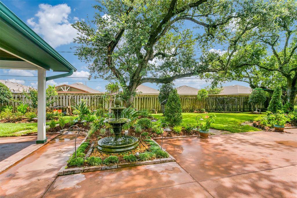 This property features a well-maintained backyard with a charming fountain centerpiece, mature shade trees, and manicured landscaping, perfect for outdoor relaxation or entertaining. The wood fencing was replaced July 2024.