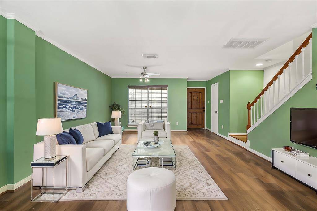 Virtually Staged: This stunning living room boasts high ceilings with a ceiling fan, beautiful wood floors, and a large window providing tons of natural light in throughout the day.