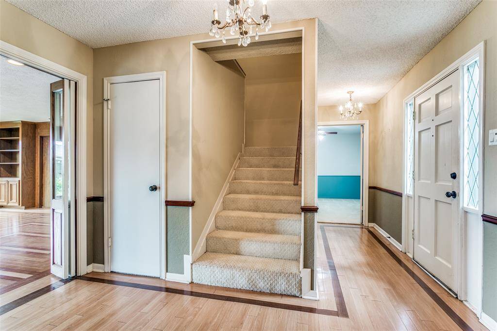 Entry way has vinyl plank flooring along with neutral wall colors. Stairs lead to second story. Also doors leading to other rooms.