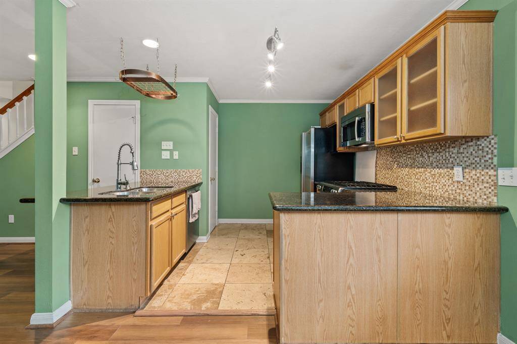 This beautiful kitchen is by far any home chef's dream! The kitchen has plenty of space to cook the perfect meal for your loved ones! Featuring wooden cabinetry, granite countertops, tile backsplash,  stainless steel appliances, large pantry, a breakfast bar, recessed and pendant lighting, and gorgeous tile flooring!