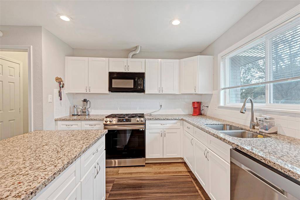 Beautifully designed kitchen featuring sleek granite countertops, modern stainless steel appliances, and convenient double sinks, ideal for both cooking and entertaining.