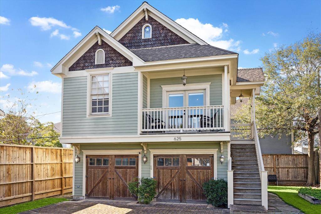 Currently used as a guest quarters and short-term rental, this dwelling boasts a 626-square-foot apartment atop two garages and overlooking an oversized fenced yard bordered by mature trees.
