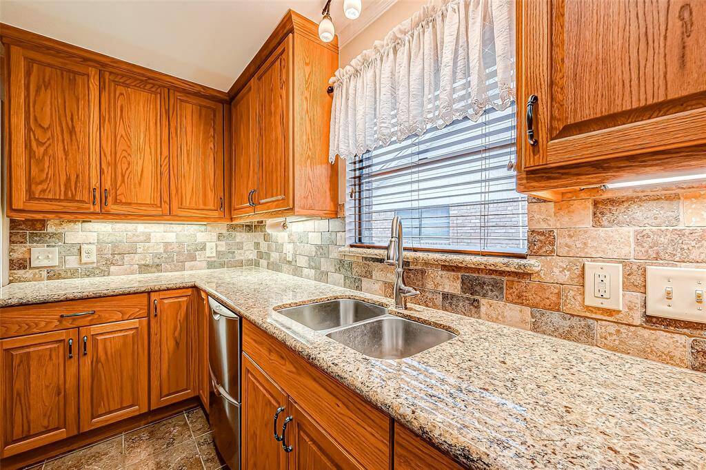 This charming kitchen invites warmth and functionality, with a picturesque window above the sink that fills the space with natural light.
