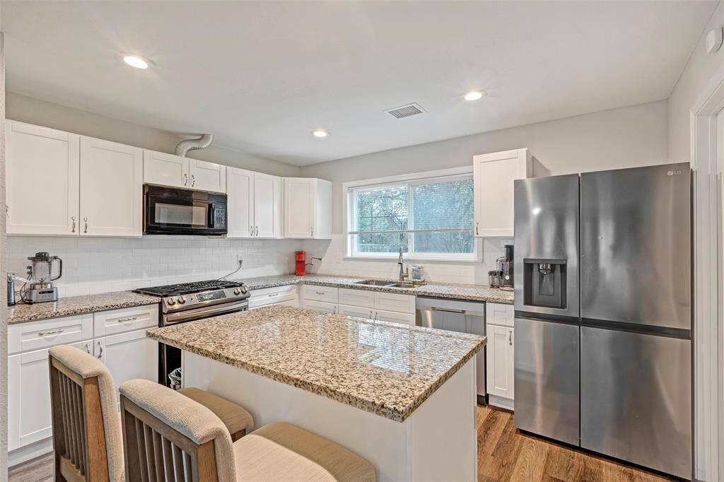 The kitchen island doubles as a functional dining table, offering a perfect spot for casual meals and gathering with loved ones.