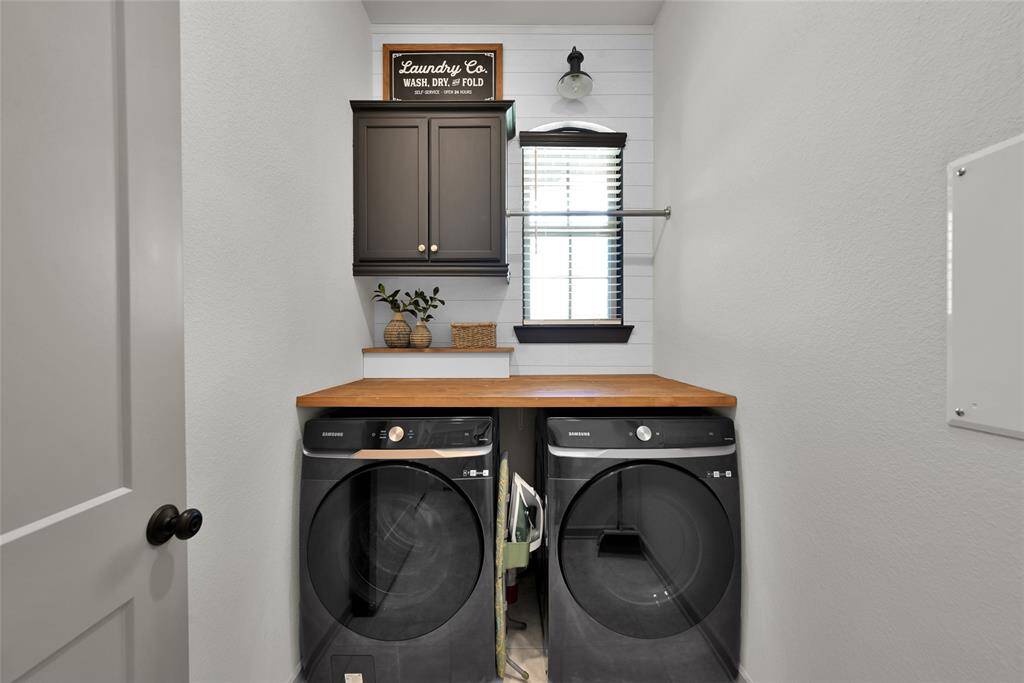 Elegantly updated laundry spacewith sleek appliances and chicdetails!