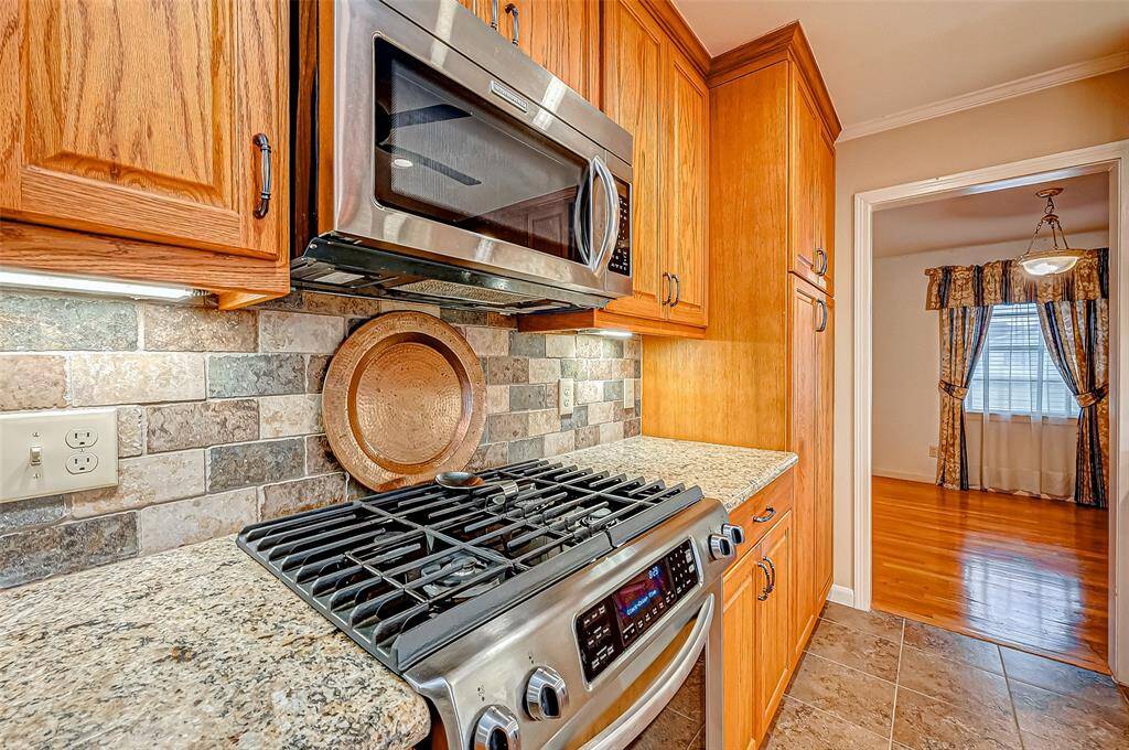 Rich wood cabinetry enhances the cozy ambiance, while the elegant tile backsplash adds a touch of rustic charm.