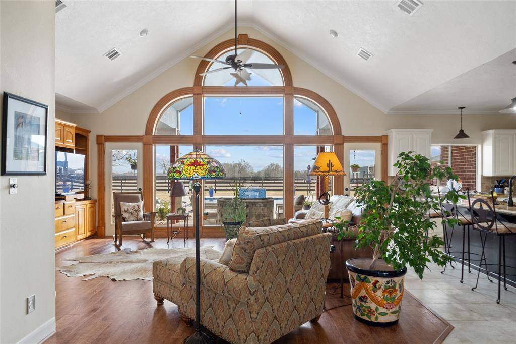 The family room brings a very original look with lots of natural lighting coming through these beautiful uniquely shaped windows, and beautiful wood floors.