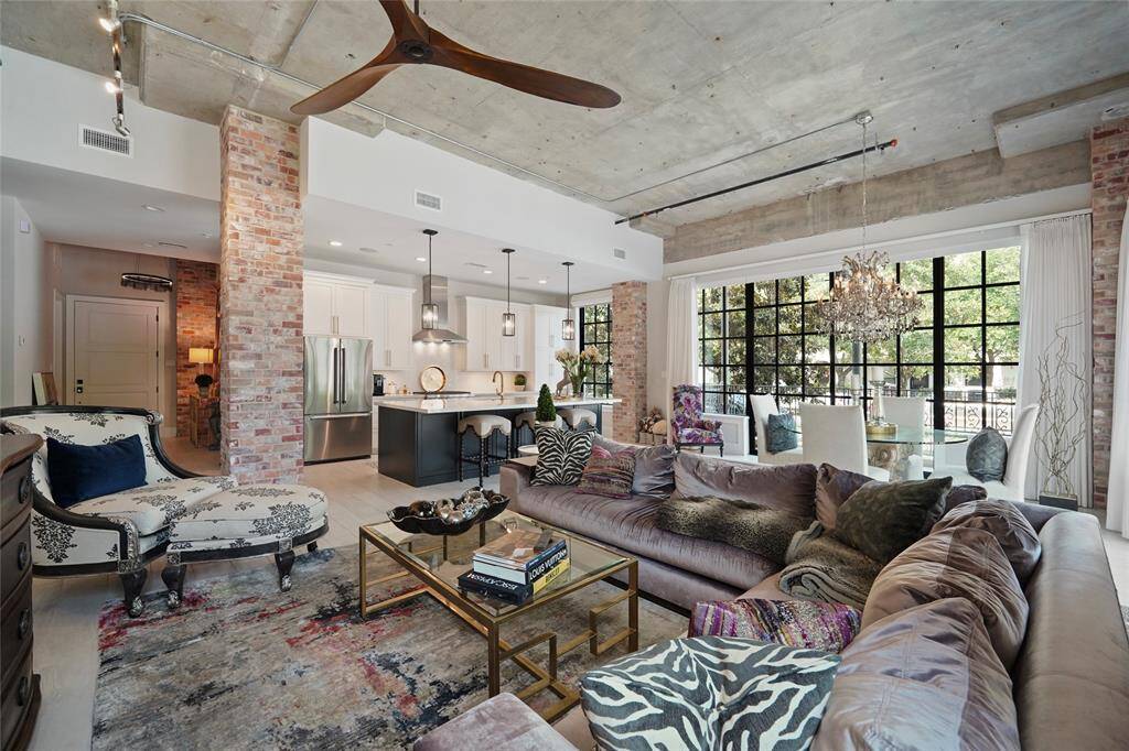 The inviting family room features 13 ft Ceiling, exposed concrete, a Tile Floor, brick-covered columns, TV mount. Floor-to-ceiling sliding doors and windows