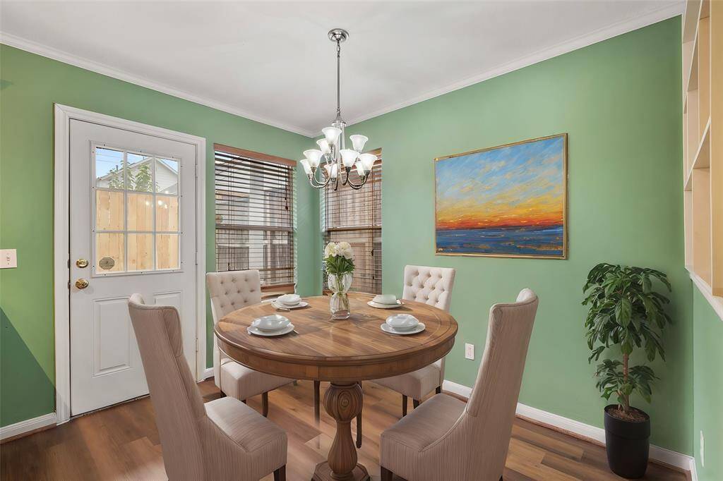 This beautiful dining area boasts a gorgeous chandelier, wood floors, and windows with direct view to your backyard!