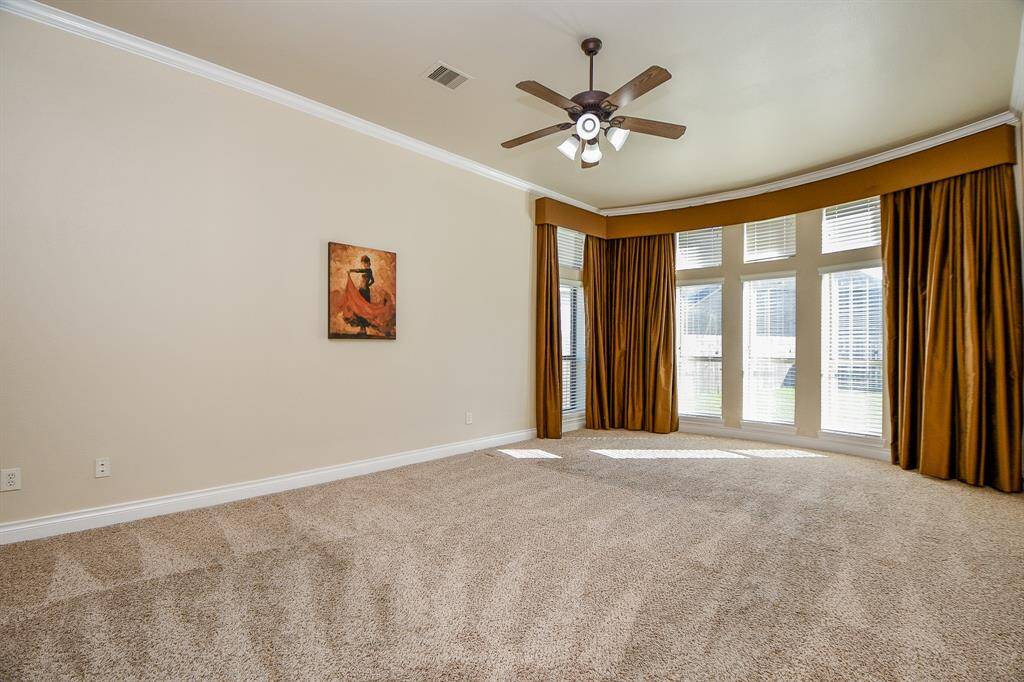 The primary bedroom features a ceiling fan and large windows for natural lighting!