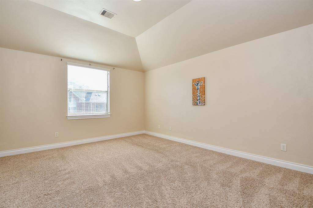 Spacious secondary bedroom upstairs featuring carpet and vaulted ceilings!