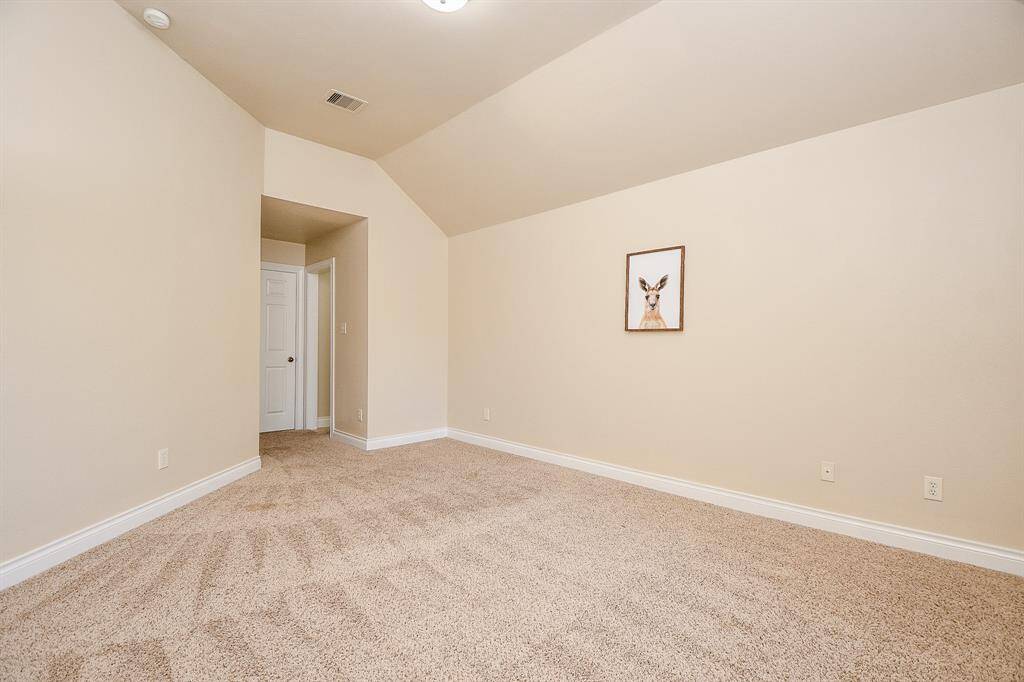 Spacious secondary bedroom upstairs featuring carpet and vaulted ceilings!