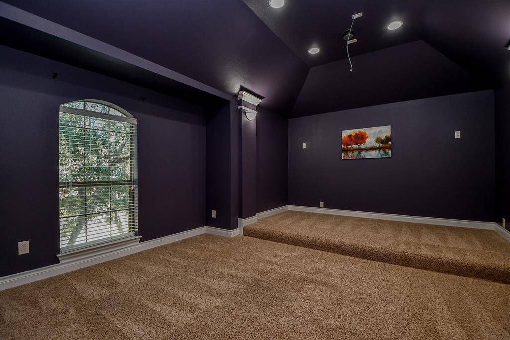 Spacious media room with recessed lighting and vaulted ceilings!