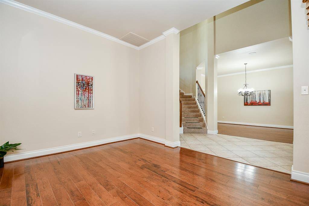 The formal living room to the left features hard wood floors and crown molding!