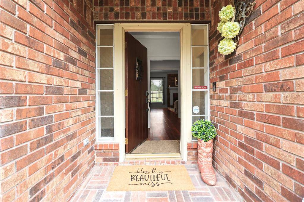 Step into your new home—a charming entrance with brick details and inviting decor welcomes you inside.