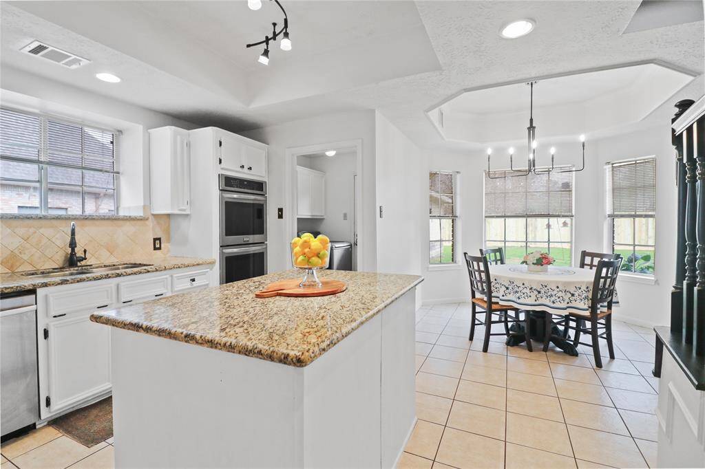 Island kitchen with a charming breakfast nook, perfect for cozy meals.