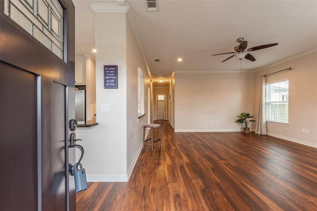 Open-concept living area with abundant natural light, neutral tones, and Shaw 30 year wide plank wood laminate flooring for durability and elegance.