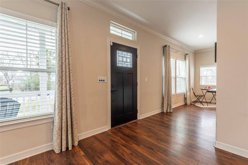 The custom front door welcomes you with beautiful design, allowing natural light to pour in and brighten the entryway.