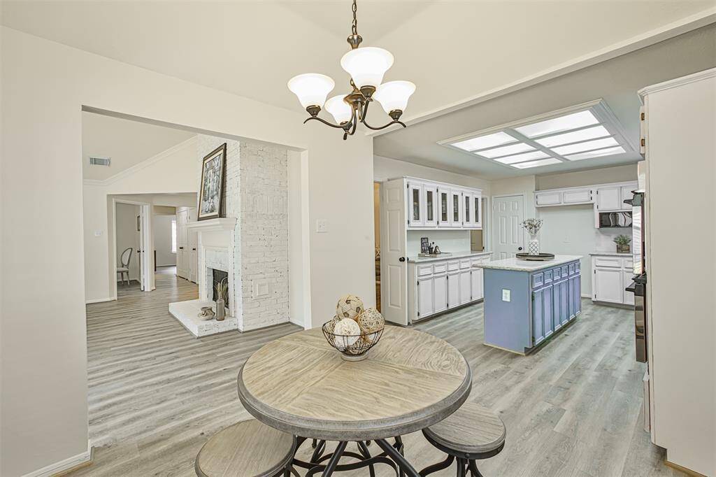 The view from the breakfast table opens to the rest of the house. As you enjoy your morning coffee, you can hear birds singing outside through the open windows, smell the freshly baked cinnamon rolls, feel the warmth of the fireplace in the living room, and see the hallway leading to kids bedrooms.