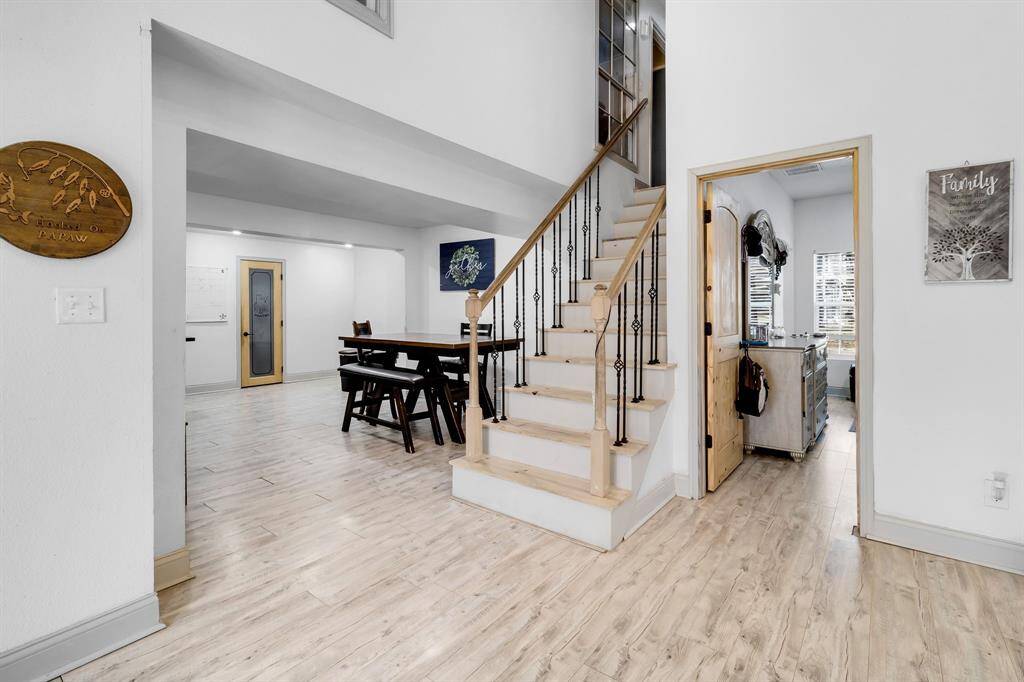 Transition area connecting the downstairs living spaces to the upstairs, featuring a cozy dining area with ample natural light—perfect for family meals or entertaining.