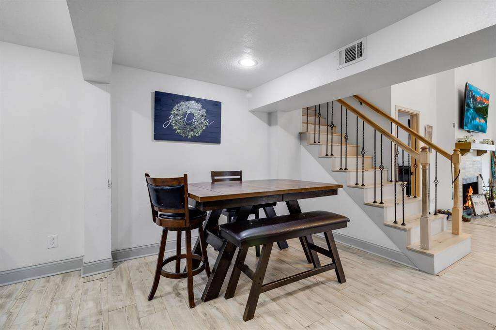 Transition area connecting the downstairs living spaces to the upstairs, featuring a cozy dining area with ample natural light—perfect for family meals or entertaining.