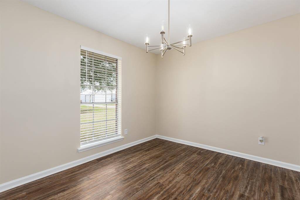 Elegant dining room with abundant natural light and stylish chandelier, perfect for gatherings.