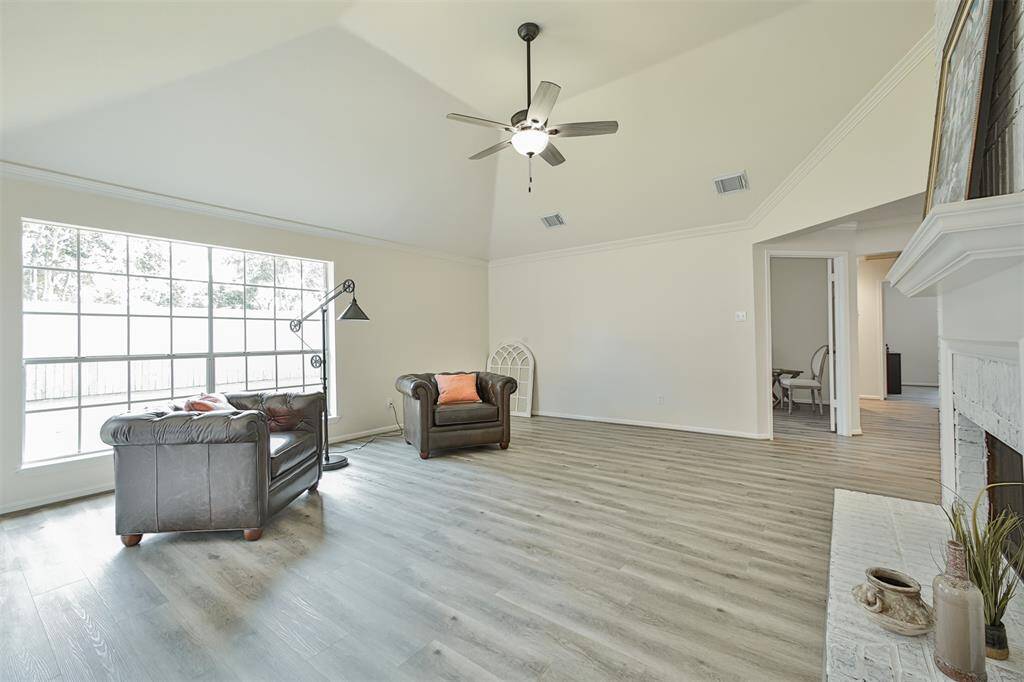 Another view of the living room gives a better view of the high ceiling and shows the enormouse size of the room. All throughout the house, including bedrooms, bathrooms, and closets, you will find oil-rubbed bronze finish and beautiful seamless vinyl wood-looking plank floor.