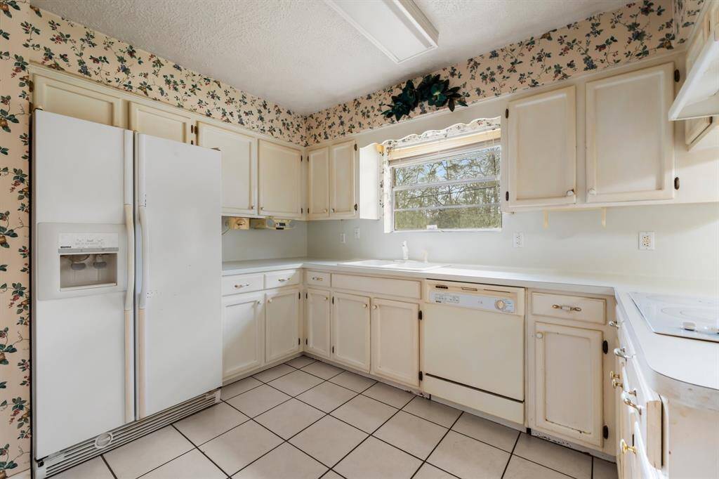 This cute and cozy kitchen offers plenty of cabinet space and awaits the perfect touch to bring it into the modern era while maintaining its charming character.