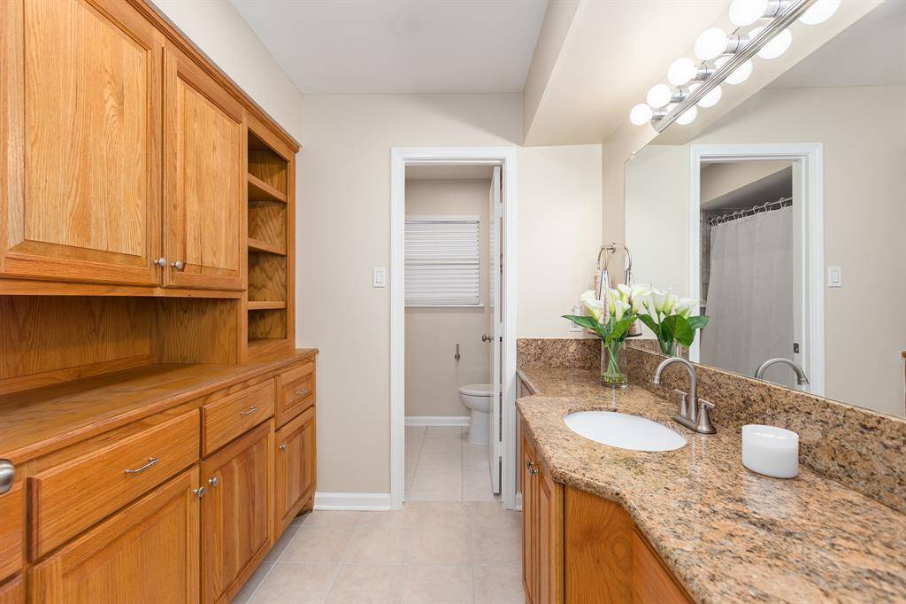 Spacious hall bath with ample storage and elegant granite countertops.