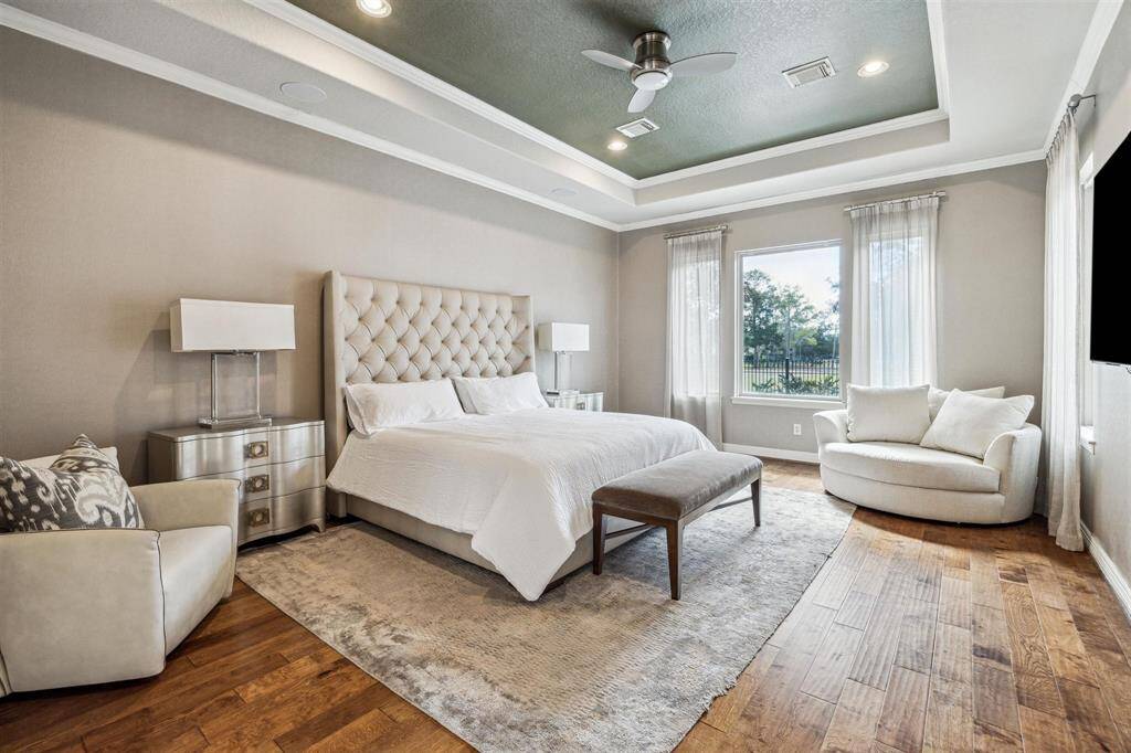 The first floor master suite has backyard access and wood flooring