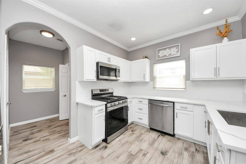 Kitchen features updated cabinets, quartz countertops and recent appliances.
