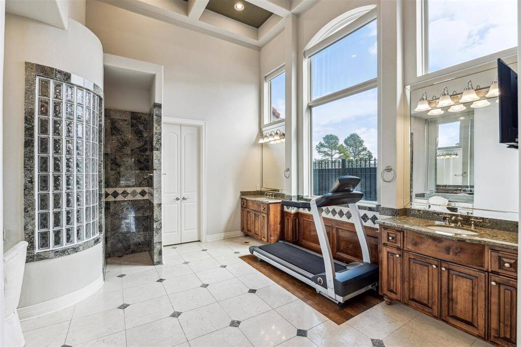 The two story bathroom has lovely storage and is bathed in natural light with auto shades, 2 walk-in closets, vanity area, linen storage and a separate water closet