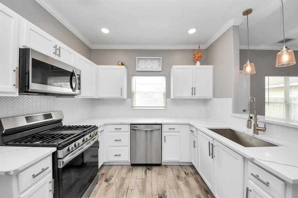 Kitchen features updated cabinets, quartz countertops and recent appliances.