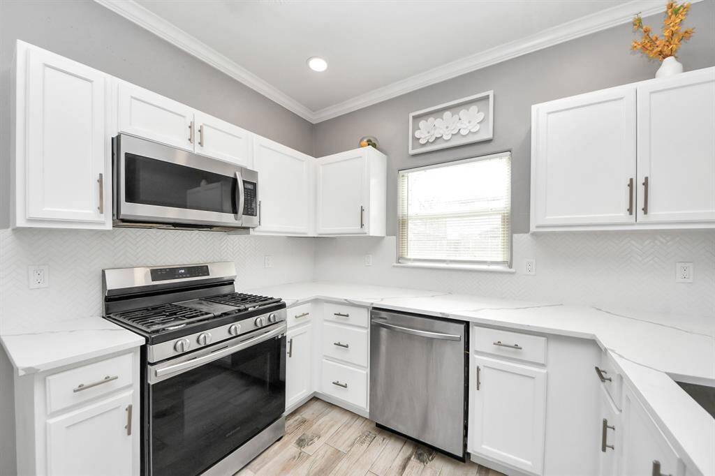 Kitchen features updated cabinets, quartz countertops and recent appliances.