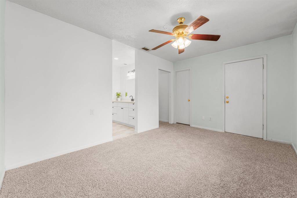The primary bedroom offers easy access to the back patio area through a private door, providing a seamless connection to outdoor living and relaxation.