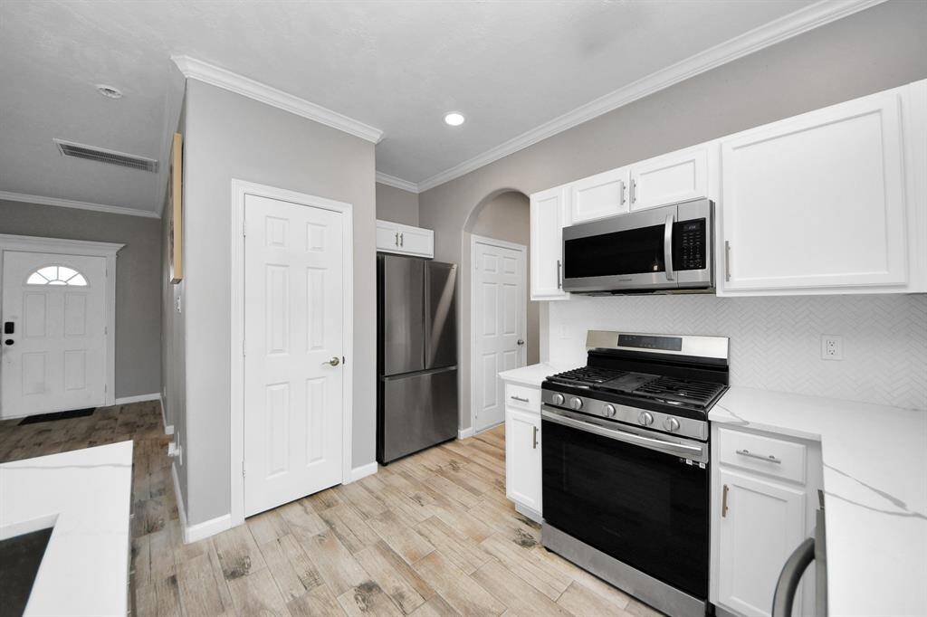 Kitchen features updated cabinets, quartz countertops and recent appliances.