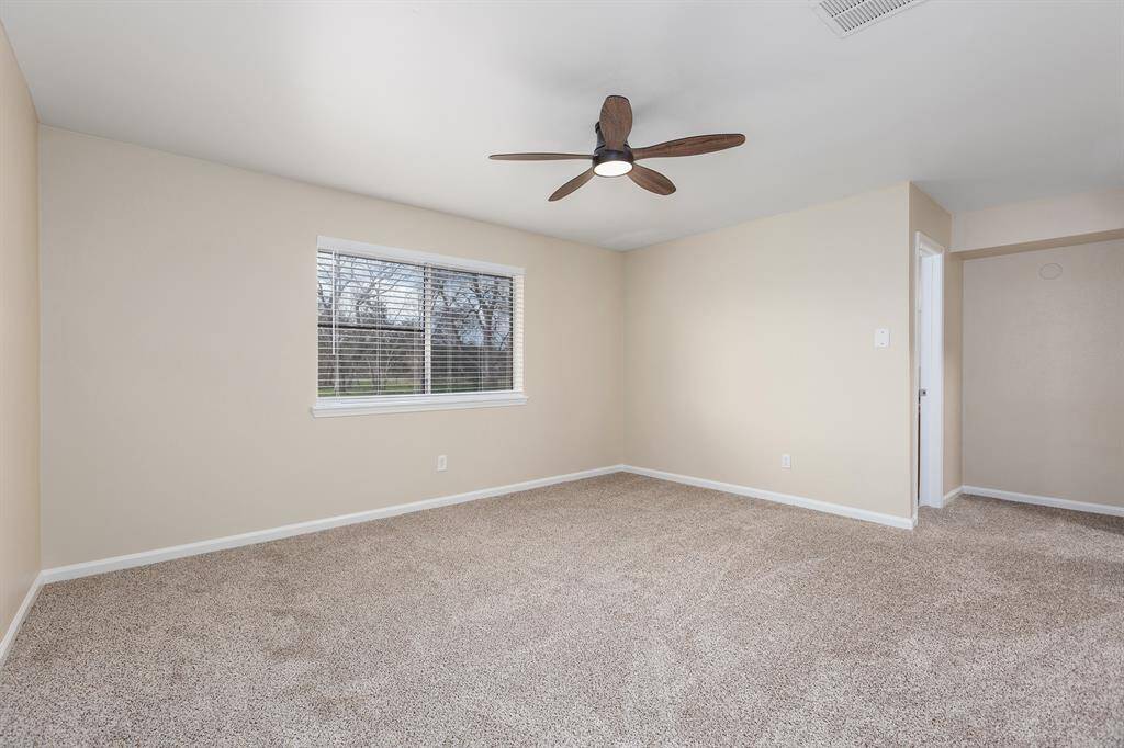 Spacious master bedroom with plush carpeting, neutral walls, and abundant natural light. Perfect for relaxation and comfort.