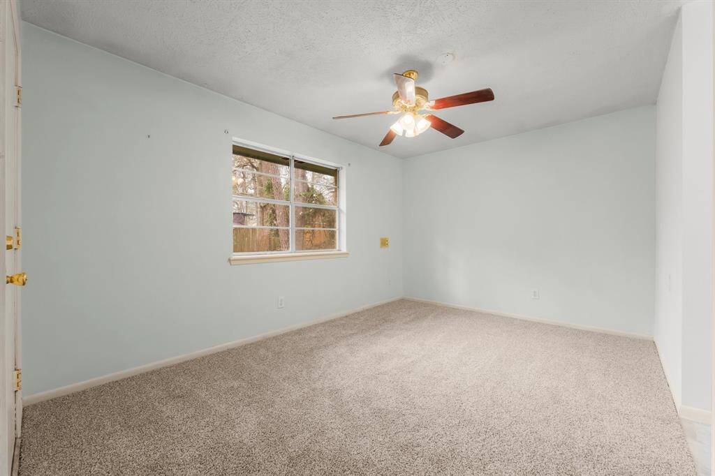 At the end of a quiet hallway, the primary bedroom offers privacy and tranquility, with a sneak peek of the beautifully updated primary bath.